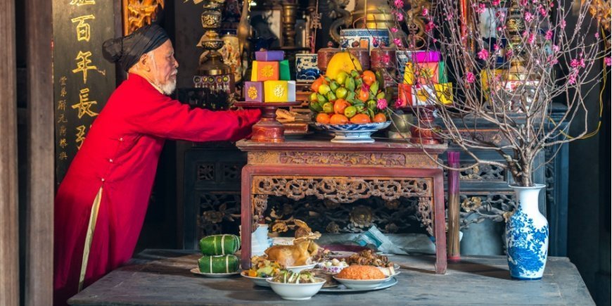 Äldre vietnamesisk man förbereder ett altare inför Tet-festivalen