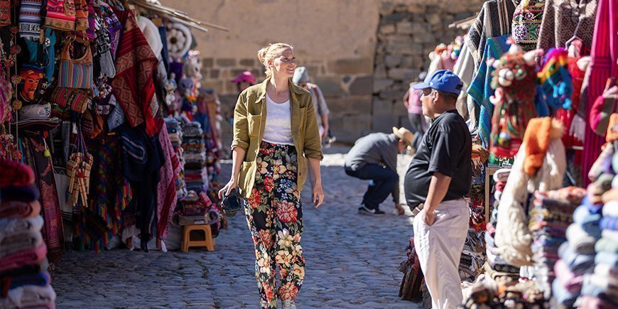 Kvinna går på lokal marknad i Cusco i Peru